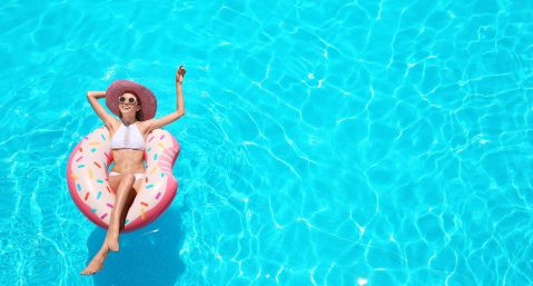 woman in sun hat on a tube in swimming pool