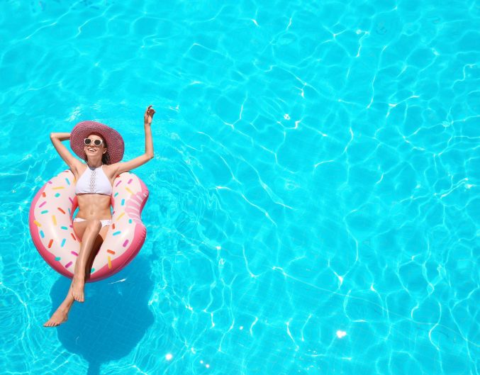 woman in sun hat on a tube in swimming pool